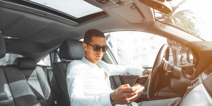 man_with_phone_in_luxury_car