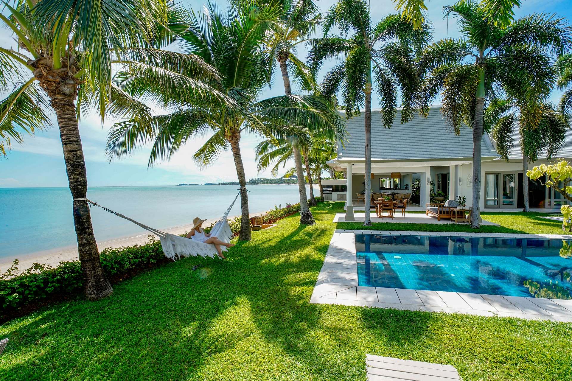 A guest rests in a hammock by the sea, enjoying a calm and easy moment at the villa